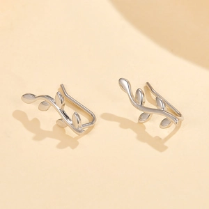 Macro shot of silver leaf-shaped ear cuff featuring a polished minimalist olive branch design