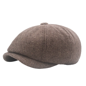 Detailed texture of brown herringbone newsboy cap with classic panel stitching