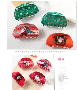 Detail of Christmas claw clips with Santa and tree motifs on a bright acrylic finish