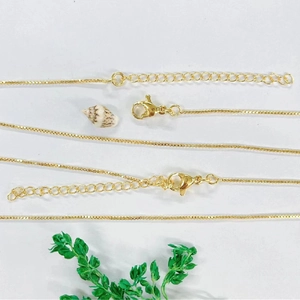 Detail of gold-plated copper box chains with lobster clasps and extension links