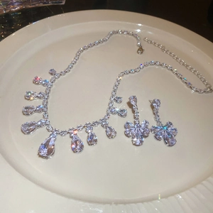 Detailed close-up of zircon water-drop fringe necklace and floral earrings set
