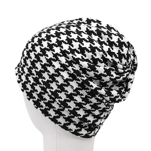 Detail shot of black and white houndstooth knit beanie showing fabric texture and pattern