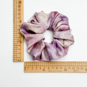 Tie-dye satin scrunchie with purple marble pattern on white background, 11cm diameter