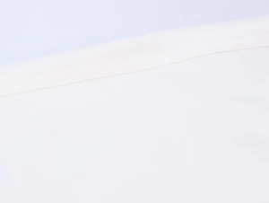 Close-up detail of white textile jacket showing high-quality stitching and fabric texture