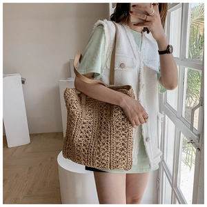 Detail of hand-woven hollow pattern tote bag with premium brown leather strap