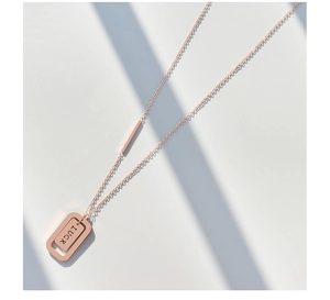 Dettaglio della collana Lucky in oro rosa con pendente rettangolare e incisione fine