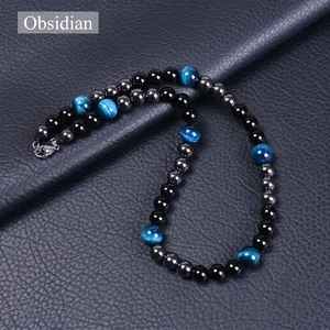Détail des perles en obsidienne, oeil de tigre bleu et hématite sur fond en cuir noir