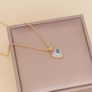 Close-up of light blue heart zircon necklace with white diamond halo on a display box