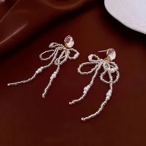 Elegant 18k gold plated earrings featuring pearl bowknot tassels and crystal accents