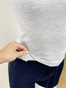 Detail shot of the elastic hem and knit texture of a grey U-neck slim fit t-shirt
