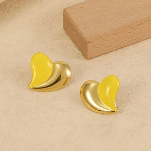 Macro shot of two-tone heart stud earrings with yellow enamel and 18K gold finish