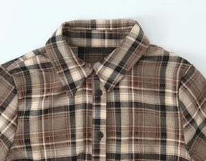 Détail du col classique et des boutons sur une chemise à carreaux marron avec texture