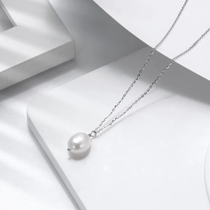 Minimalist silver necklace with a natural baroque pearl pendant on a geometric base