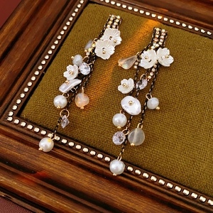 Detail of vintage flower tassel earrings with pearls and crystals on green velvet