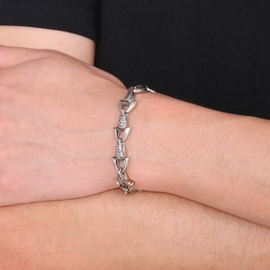 Macro detail of men's vintage stainless steel fish bone link bracelet on wrist