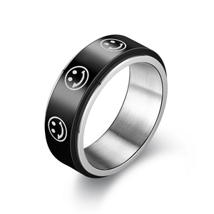 Primer plano de un anillo giratorio de acero inoxidable con banda negra y caras sonrientes