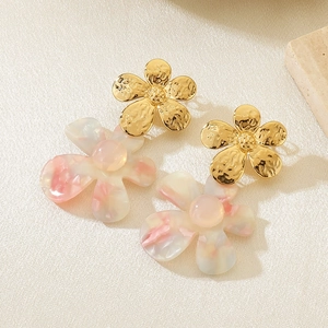 Detail of French vintage gold flower earrings with pink resin petals on textured fabric