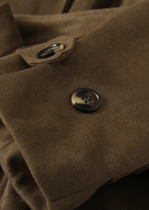 Détail d'un manteau en daim synthétique marron foncé avec bouton en écaille et tissu texturé