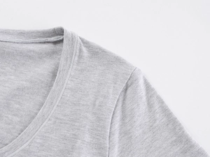 Macro shot of U-neckline and shoulder seam stitching on gray knitted T-shirt