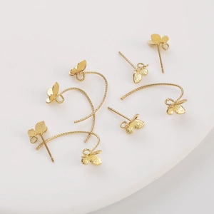 14K gold plated butterfly earrings and hooks with textured surface on a white tray