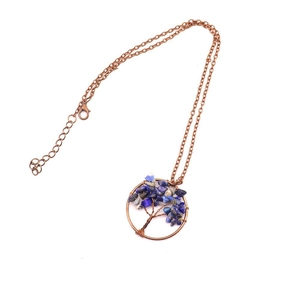 Detailed view of Tree of Life pendant with copper wire and blue crystal stones on white background