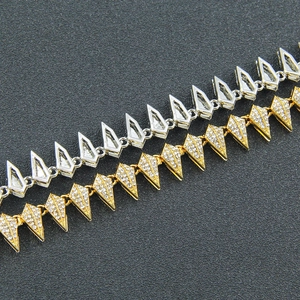 Detail of silver hollow spikes and gold diamond-encrusted chain links for men