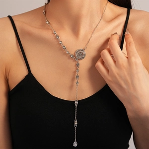 Detail of silver long Y-shaped sweater chain with zircon flowers and waterdrop pendants