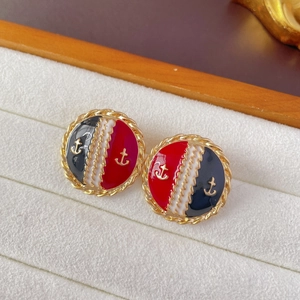 Close-up of vintage nautical anchor earrings with red and blue enamel in a jewelry box