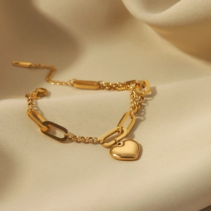 Elegant 18k gold plated heart pendant bracelet with chunky links on yellow silk background