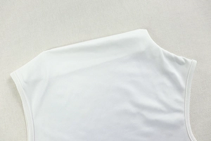 Detailed close-up of the clean neckline and stitching on a white slim-fit knit top