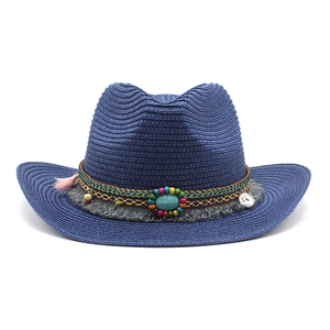 Détail d'un chapeau de cowboy en paille style bohème avec perles et franges