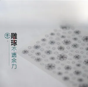 Macro shot of 5D nail stickers featuring black cherry blossom outlines on matte texture
