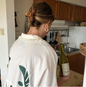 Blusa blanca con cuello de volantes, estampado de hojas verdes y pinza de pelo ámbar