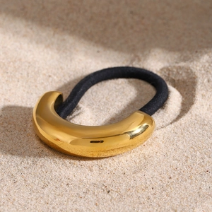 Detail of high-elastic black hair tie with polished U-shaped gold metal accessory