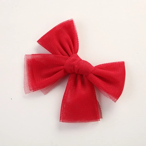 Detailed close-up of a red mesh butterfly hair bow with fine fabric texture