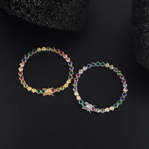 Colorful heart-shaped tennis bracelet with gold and silver finishes on black rock