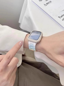 Detail of gradient pastel PVC link band and matte cream case on an Apple Watch