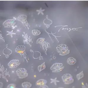 Macro shot of 3D embossed ocean nail stickers with iridescent shells and jellyfish