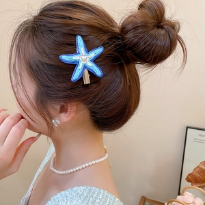 Gros plan détaillé d'une pince à cheveux étoile de mer en raphia bleu sur un mannequin