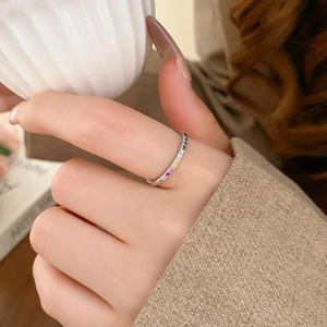 Close-up of a silver ring with rainbow cubic zirconia stones on a model's hand
