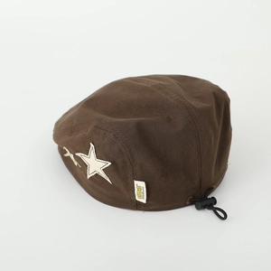 Detail of vintage brown kids beret with star patch and adjustable drawstring toggle