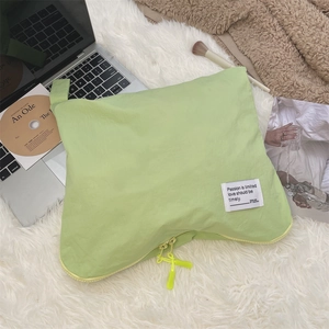 Detail showing the light green waterproof pouch with zipper and woven quote label
