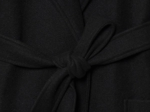 Detail of black wool blend coat showing fabric texture and adjustable waist belt tie
