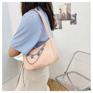 Detail of light pink PU leather shoulder bag featuring a decorative butterfly metal chain