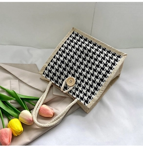 Detail of houndstooth canvas tote bag with woven rope handle and wooden button closure