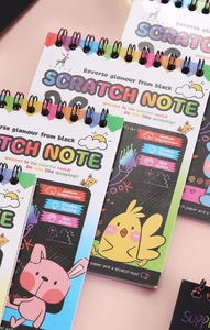 Detail view of colorful children scratch note notebooks with spiral binding and cartoon animal