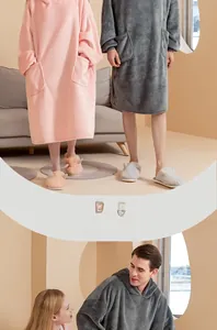 Detail view of pink and grey oversized fleece hoodie blankets with matching plush slippers