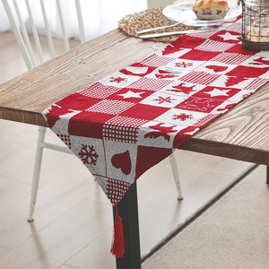 Christmas table runner with red elk and snowflake patterns featuring tassel edges