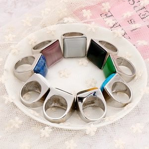 Collezione di anelli con pietre quadrate colorate su un elegante tessuto di pizzo