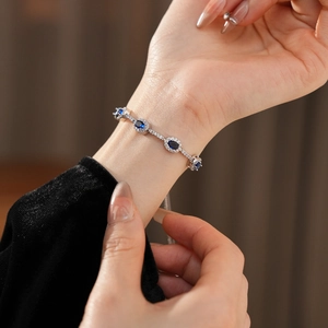 Nahaufnahme des eleganten Silberarmbands mit ovalem blauem Zirkon und Pavé-Fassung